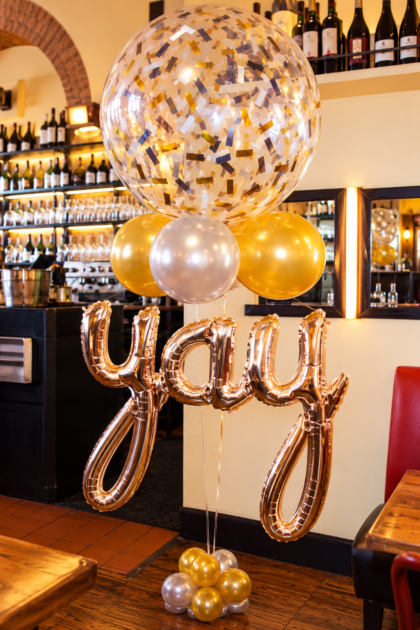Six-foot-tall YAY balloon bouquet featuring a 36-inch confetti-filled balloon, gold and silver latex balloons, and rose gold foil lettering.
